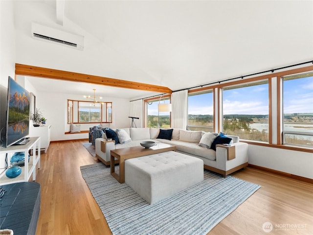 living room featuring baseboards, a water view, light wood-type flooring, a chandelier, and a wall mounted AC