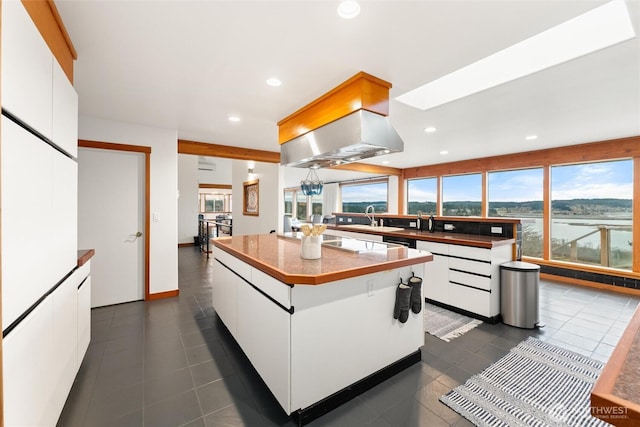 kitchen featuring a center island, white cabinets, dark countertops, and recessed lighting