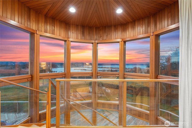 sunroom / solarium featuring elevator, wooden ceiling, and a water view