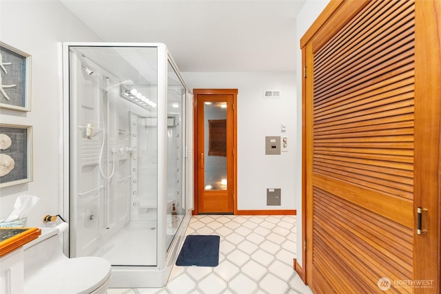 full bathroom with a stall shower, visible vents, baseboards, toilet, and tile patterned floors