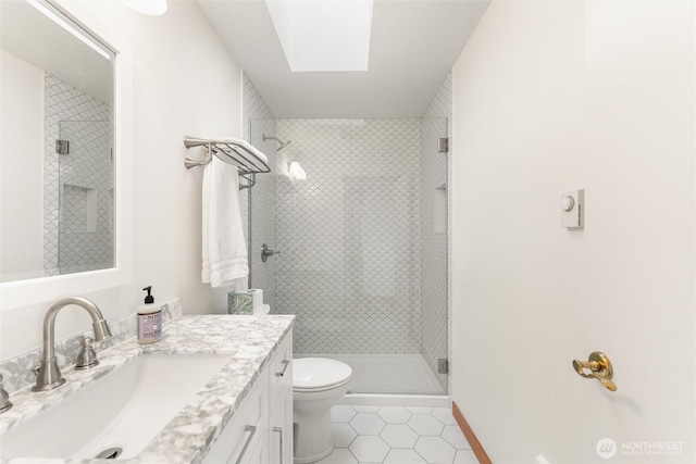 full bathroom with a skylight, toilet, tile patterned flooring, vanity, and a shower stall