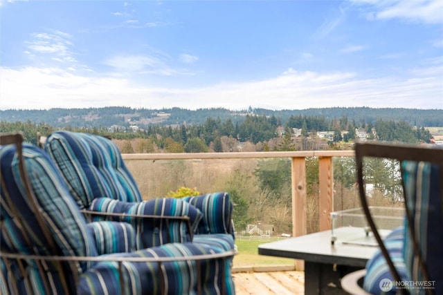 balcony featuring an outdoor living space and a wooded view