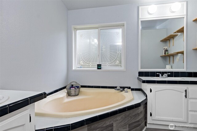 full bathroom with a bath and vanity