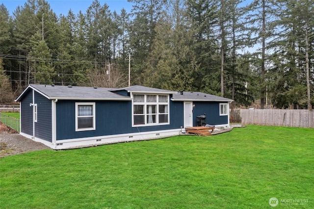 back of house featuring crawl space, fence, and a yard