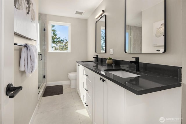 bathroom featuring a stall shower, visible vents, a sink, and toilet