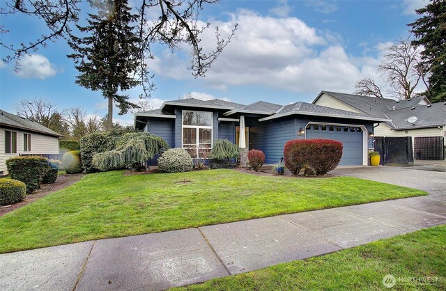 view of front of house featuring fence, driveway, a front yard, and an attached garage