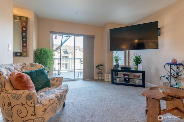 living area featuring lofted ceiling, carpet, and baseboards