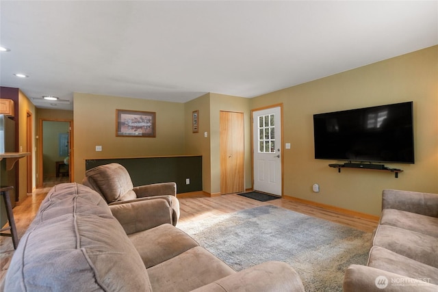 living room with recessed lighting, baseboards, and light wood finished floors