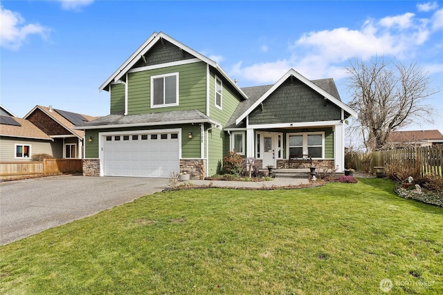 craftsman inspired home featuring driveway, an attached garage, fence, and a front lawn