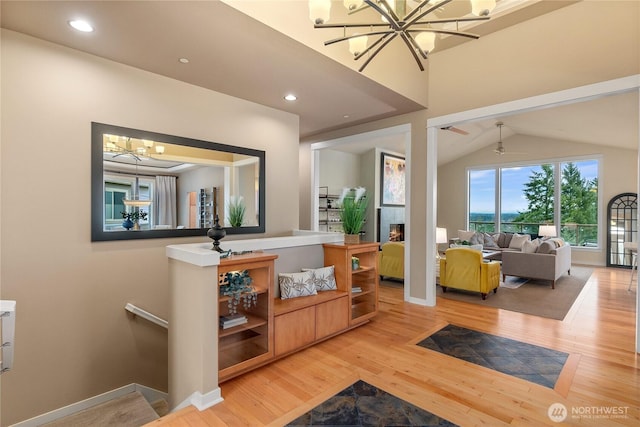 interior space with a notable chandelier, wood finished floors, recessed lighting, a fireplace, and baseboards