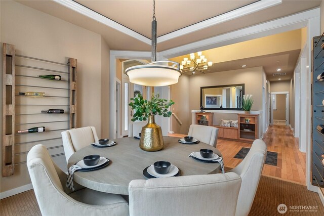 dining room featuring light wood-type flooring, baseboards, and a chandelier