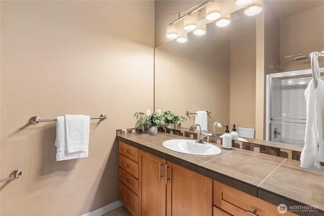 bathroom featuring an enclosed shower, toilet, and vanity