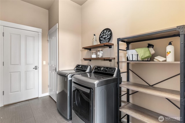 laundry room featuring washing machine and clothes dryer and tile patterned flooring