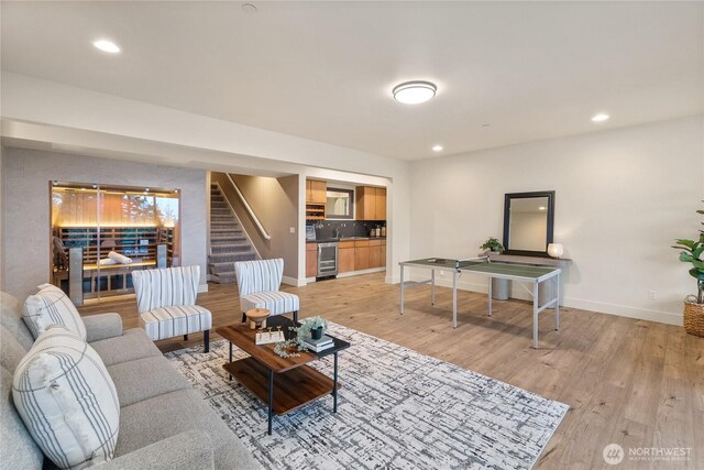 living area featuring recessed lighting, stairway, baseboards, and light wood-style floors