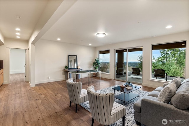 living room with light wood finished floors, recessed lighting, and baseboards