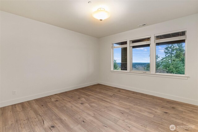 empty room with visible vents, baseboards, and light wood-style floors