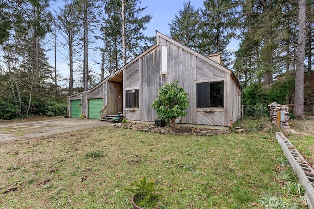 exterior space featuring driveway, an attached garage, and a yard