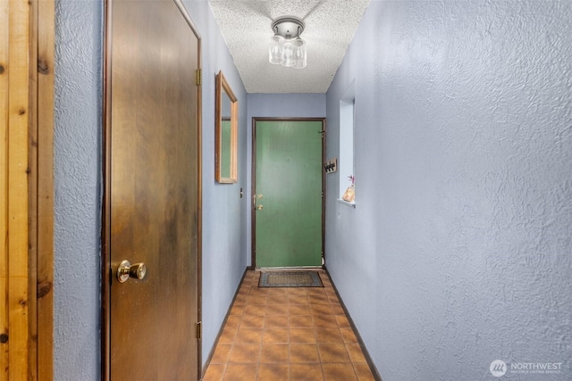 entryway featuring a textured ceiling, a textured wall, and tile patterned flooring