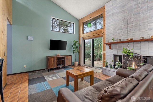 living area with high vaulted ceiling, plenty of natural light, a fireplace, and tile patterned floors