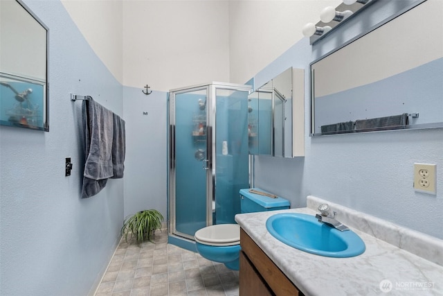 full bath with toilet, a stall shower, and vanity