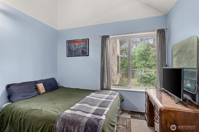 bedroom with lofted ceiling, carpet flooring, and visible vents