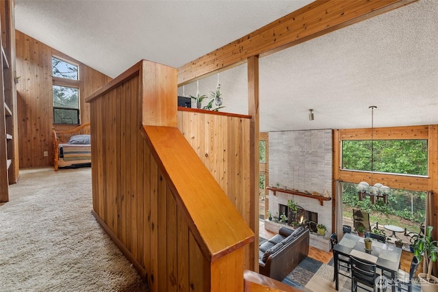 interior space with carpet floors, wooden walls, a fireplace, and a textured ceiling