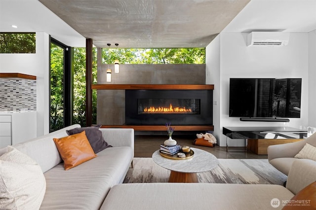 living area with a wall of windows, a wall mounted air conditioner, and a glass covered fireplace