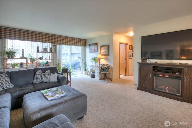 carpeted living room with a glass covered fireplace