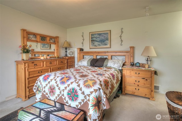 bedroom featuring visible vents and light colored carpet