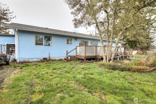 rear view of house featuring a deck and a yard