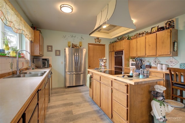 kitchen with light countertops, stainless steel appliances, a sink, and under cabinet range hood