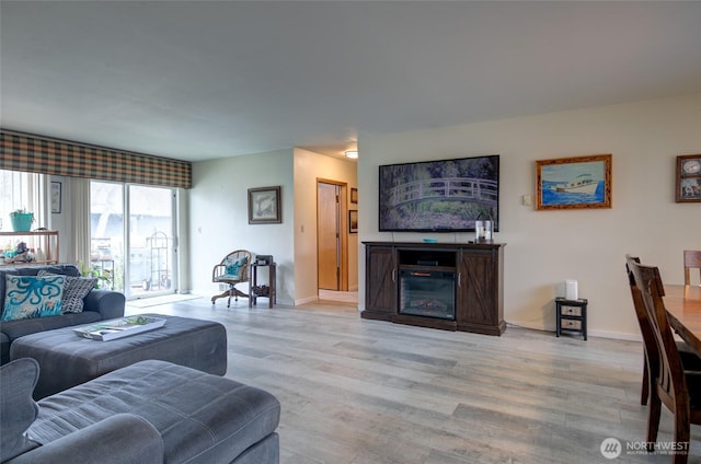 living area with light wood-style flooring and baseboards