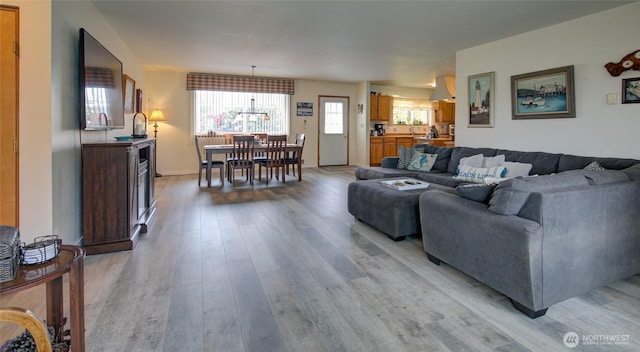 living area featuring light wood finished floors and an inviting chandelier