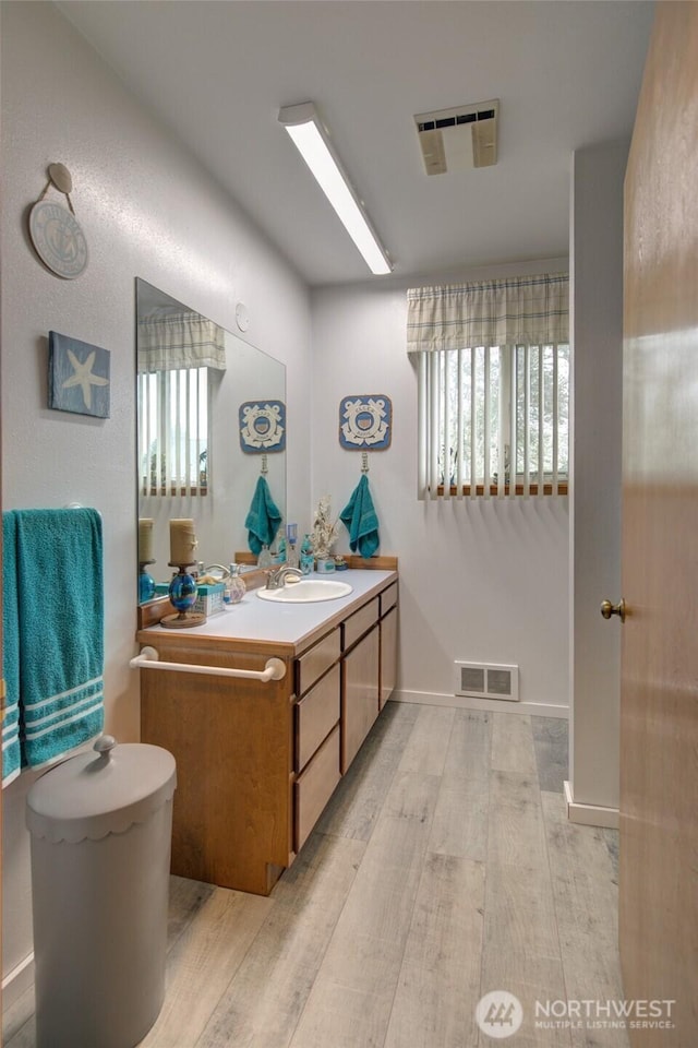 bathroom featuring vanity, toilet, visible vents, and wood finished floors