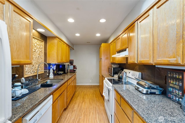 kitchen with tasteful backsplash, white appliances, a sink, and under cabinet range hood