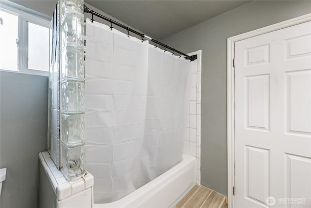 full bath featuring shower / bath combo with shower curtain and wood finished floors