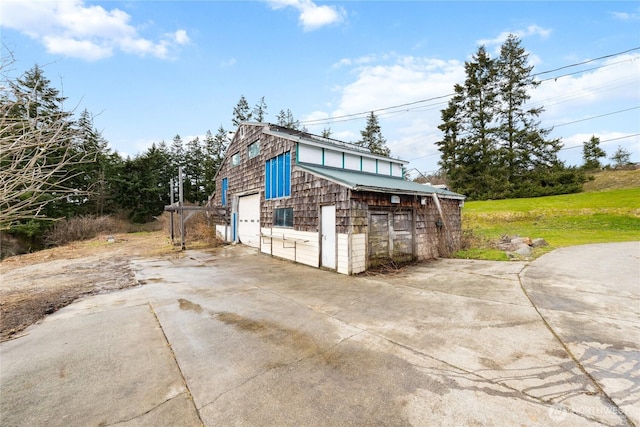 view of side of home with a garage and driveway