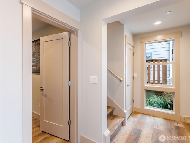 hallway with light wood-style floors, recessed lighting, stairway, and baseboards