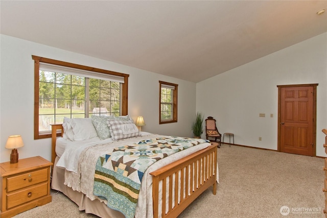 bedroom with lofted ceiling, light colored carpet, and baseboards