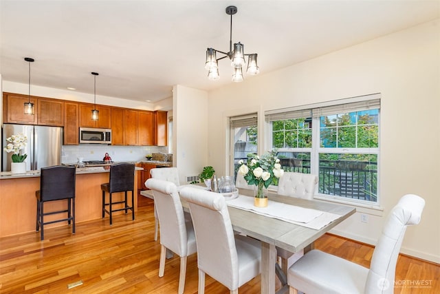 dining space with light wood-style floors, recessed lighting, baseboards, and an inviting chandelier