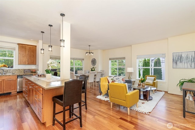 kitchen with a breakfast bar, brown cabinets, light countertops, open floor plan, and a kitchen island