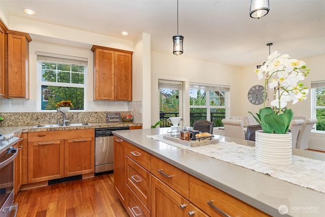 kitchen with pendant lighting, a sink, stainless steel dishwasher, and stove