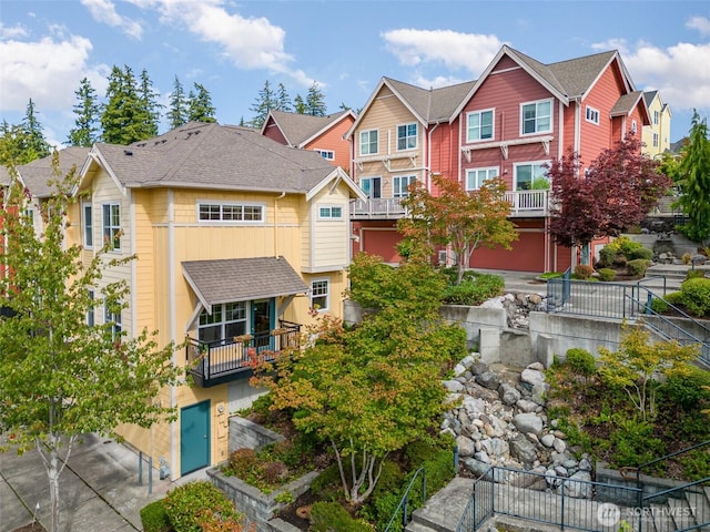 view of front of house featuring a residential view, concrete driveway, and an attached garage