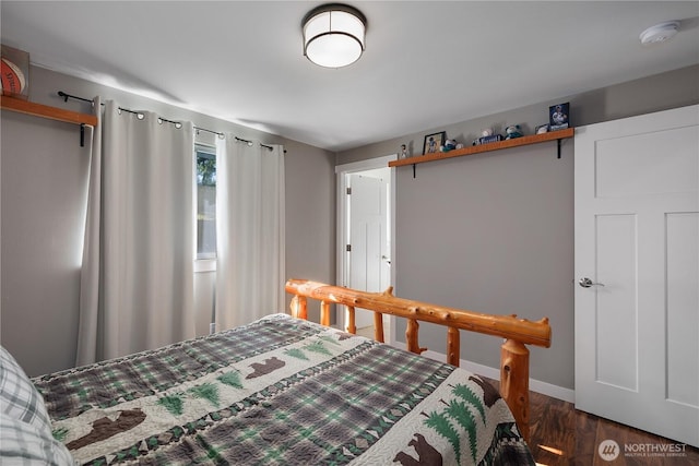 bedroom with wood finished floors and baseboards