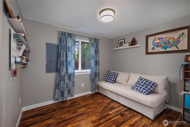 living area featuring visible vents, electric panel, baseboards, and wood finished floors