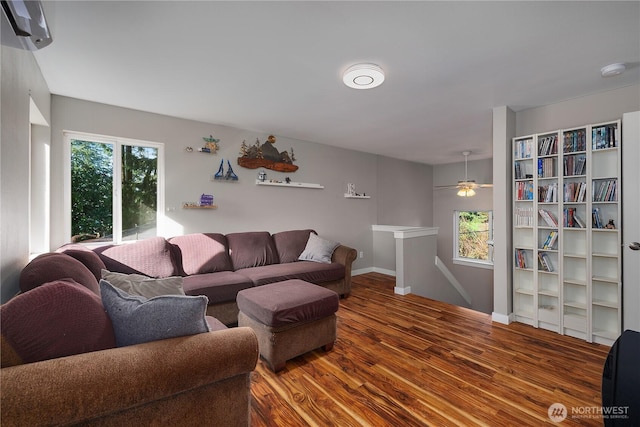 living area with plenty of natural light, baseboards, and wood finished floors