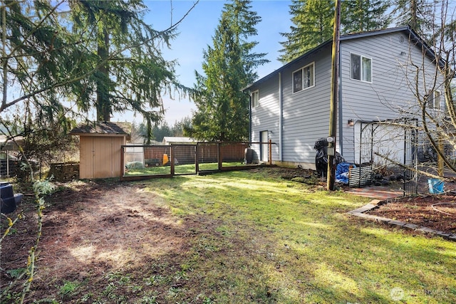 view of yard with an outbuilding, fence, and a storage shed