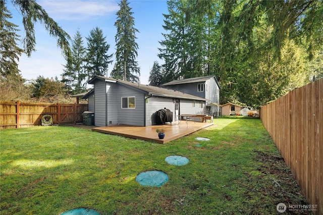 back of property with a yard, a fenced backyard, and a wooden deck