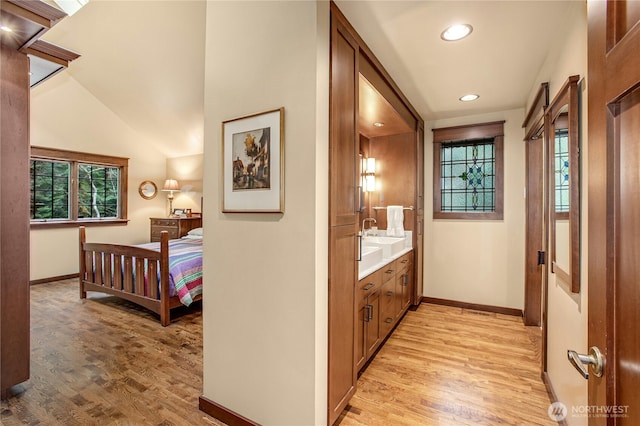 corridor featuring a healthy amount of sunlight, light wood-style flooring, and baseboards