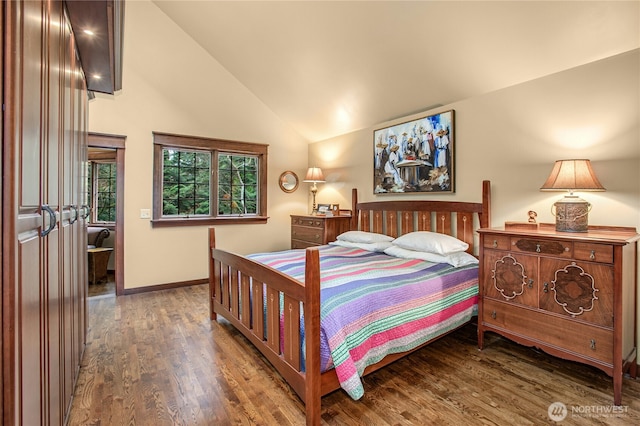 bedroom with lofted ceiling, baseboards, and wood finished floors